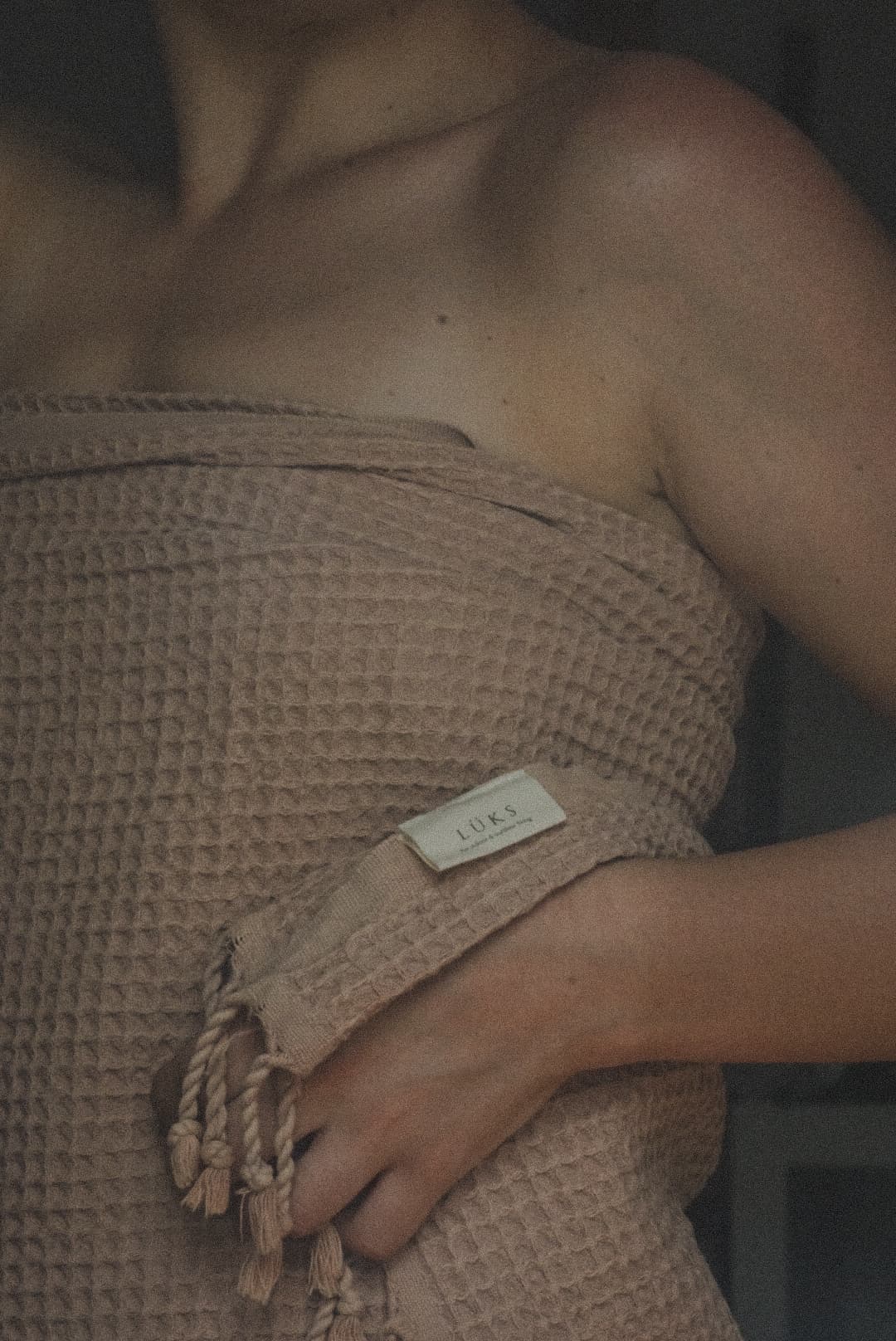 Woman wrapped in towel, relaxed after body contouring treatment