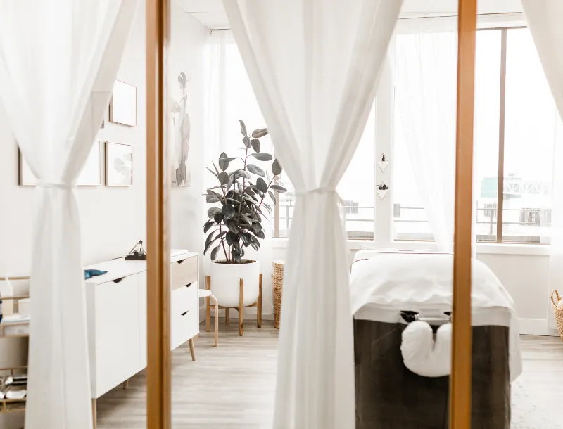 Treatment room at Next Ov Skin in Edmonds with white curtains and natural light