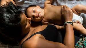Mother lying with baby in tender intimate moment