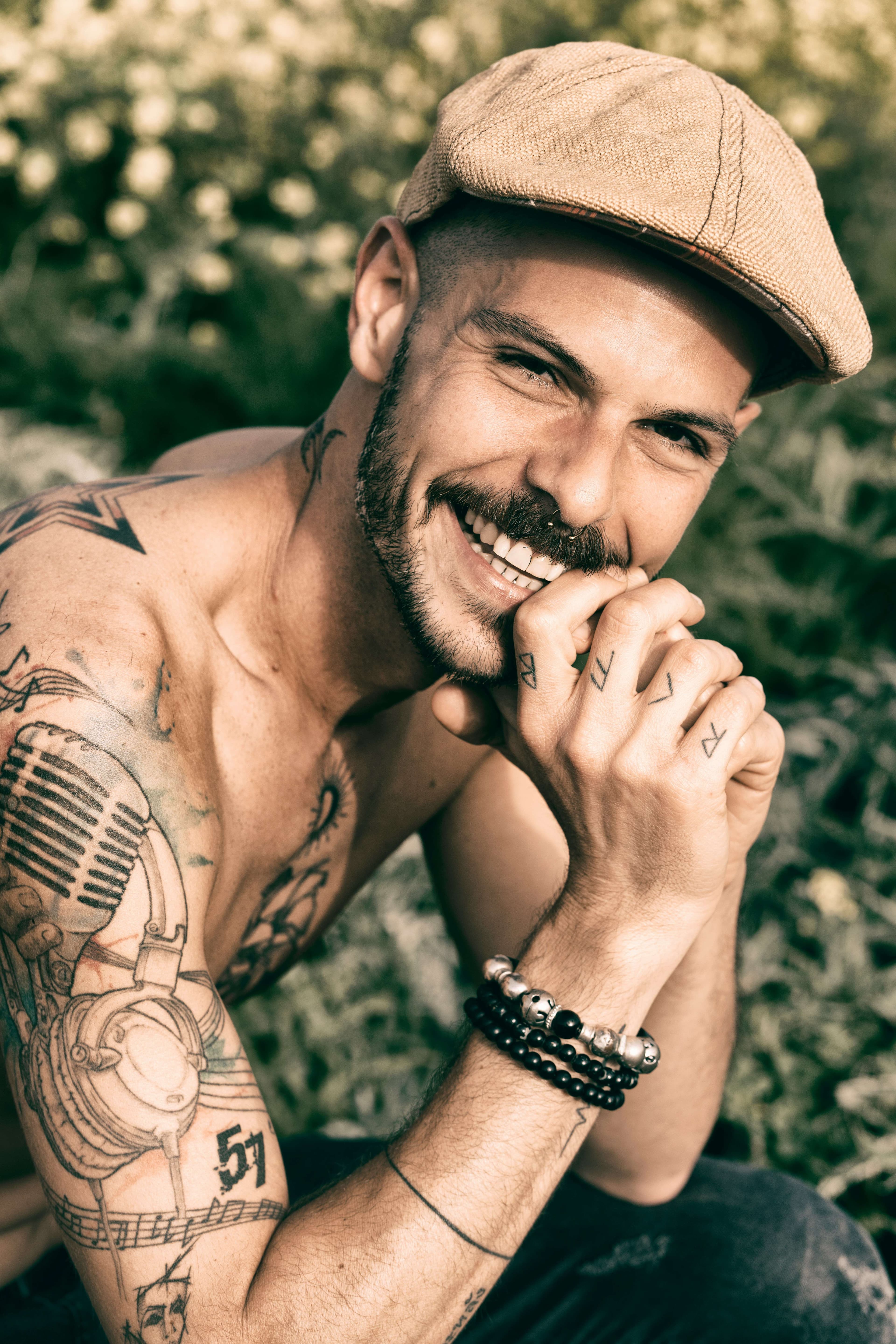 Man with arm tattoos smiling after consultation at NOVS