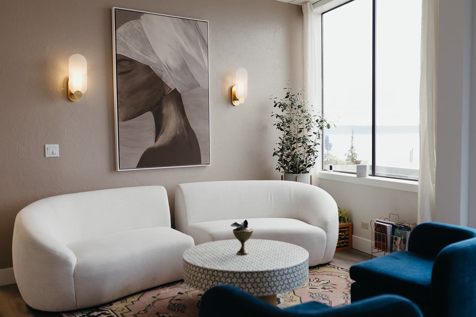 Next OV Skin elegant lobby with curved white sofa, warm lighting, and waterfront views